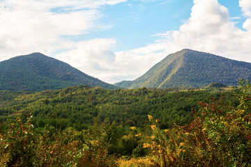 Fototapeta premium Autumn Mountain Landscape with Green Fields and Grassy Foothills
