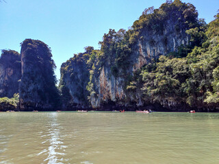 Limestone cliffs with people kayaking in Hong Island of Thailand.