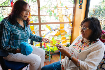 Elderly Friends Sharing Knitting Tips with Smiles and Yarn