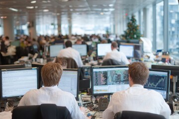 Group of financial analysts working in office during the day at desks with computers in London, England