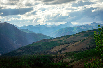 Expansive overlook of the San Juan Mountains near Lake City, Colorado, with layered peaks fading into the horizon under dramatic skies, showcasing the wild beauty of the Rockies.