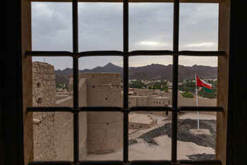 Bahla , Oman - July 25 2025: View from a window inside Bahla Fort in Oman, showing traditional mud...