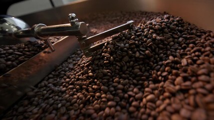 Freshly roasted brown coffee beans cooling and stirring process showcased in dynamic sequence. - Powered by Adobe