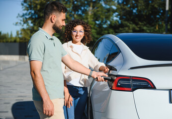 Couple charging electric car at home, embracing green energy and sustainability