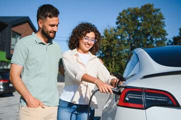 Couple charging electric car at home, embracing green energy and sustainability