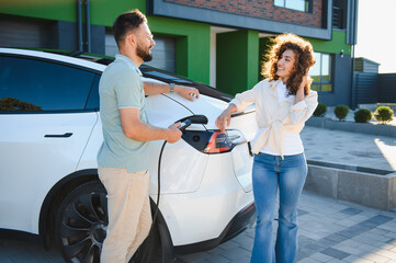 Couple charging electric car at home, embracing green energy and sustainable lifestyle