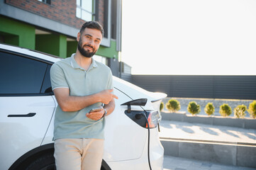 Man Charging Electric Car at Modern Home