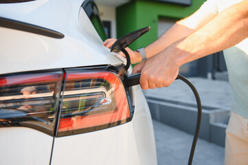 Charging an electric car at home in the driveway