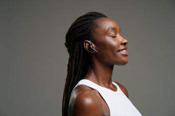 Smiling Young Black Woman Listening to Music with Wireless Earbuds