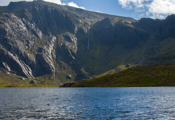 a beautiful lake and a stream flowing down from the mountain