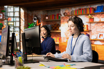 Upbeat call center agent in talking in audio headset, helping customers regain access to accounts...