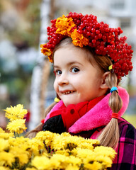 
Portrait of a Smiling Girl with a Bright Wreath and Yellow Flowers