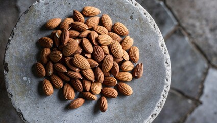 An artistic arrangement of almonds on a rustic stone surface.