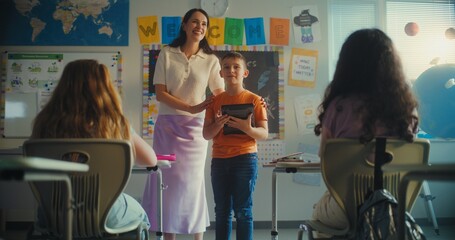 STEM Class on Renewable Energy: Female Teacher Presenting Elementary School Student. Talented Boy...