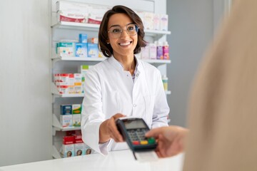 Female Pharmacist Taking Mobile Payment at Pharmacy Counter