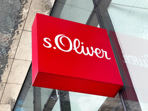 Villach, Austria - July 30, 2025: s.Oliver brand logo displayed prominently on a red sign outside a modern retail store, showcasing contemporary fashion and branding aesthetics