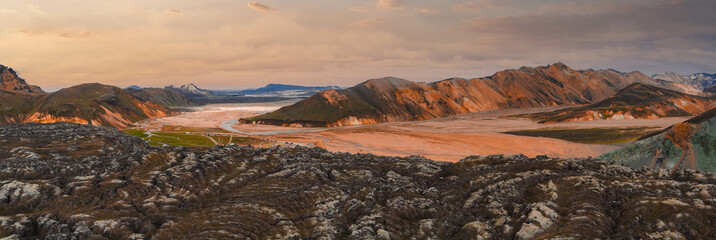 Aerial view of Iceland's Landmannalaugar region with colorful rhyolite hills, dark lava fields, a...