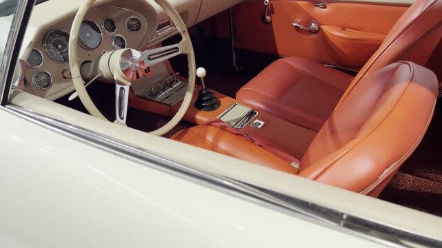 Vintage car interior featuring leather seats, retro dashboard, and manual gear shift. 