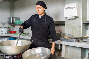 Latin chef cooking peruvian food in restaurant kitchen