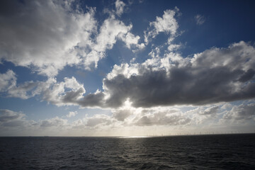 Obraz premium Scenic view of clouds over the North Sea with wind turbines on the horizon during daytime
