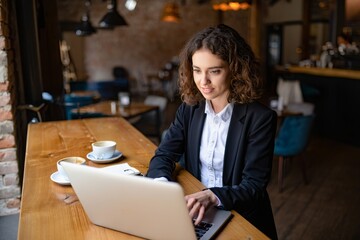 Young Woman Working on Laptop in Coffee Shop