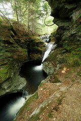 Majestic waterfall cascading through rocky landscape in a serene forest setting during daylight