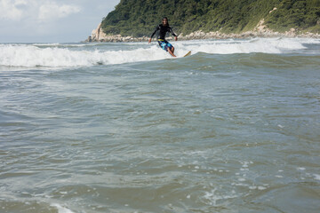 Latin surfer man rides the tropical waves in Mexico Latin America, hispanic people surfing in summer in sport activity concept 