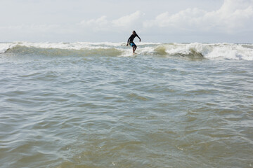 Latin surfer man rides the tropical waves in Mexico Latin America, hispanic people surfing in summer in sport activity concept 