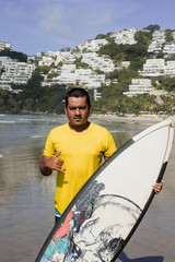 Latin surfer man rides the tropical waves in Mexico Latin America, hispanic people surfing in summer in sport activity concept 