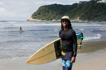Latin surfer man rides the tropical waves in Mexico Latin America, hispanic people surfing in summer in sport activity concept 