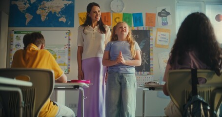 Female Teacher Presenting Young Student During Ecology Lesson in Modern Classroom. Primary School...