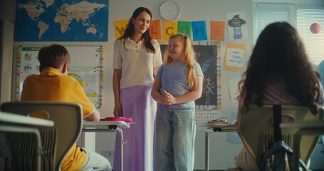 Female Teacher Presenting Young Student During Ecology Lesson in Modern Classroom. Primary School...