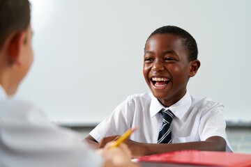 Smiling Schoolboy Laughing with Friend in Classroom