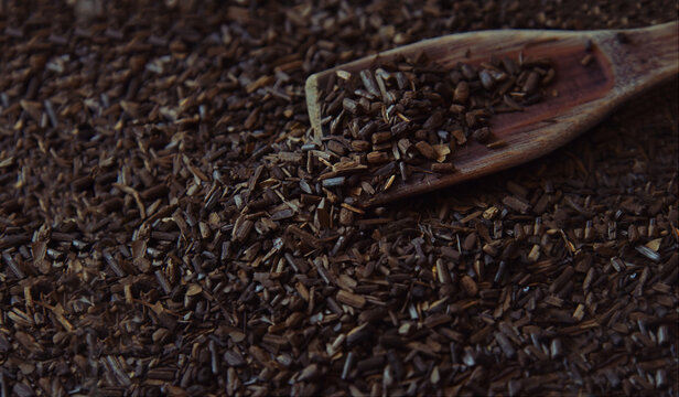 Erva-Mate, roasted mate herb for tea. Toasted Mate Tea and a wooden spoon. Traditional Brazilian beverage. Close-up