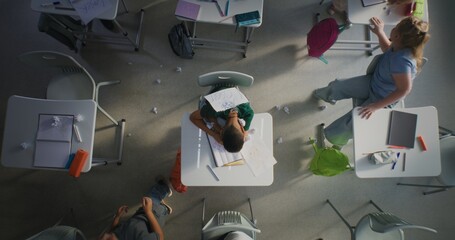 Sad African American Elementary Boy Student Sitting at Desk and Crying While Classmates Bullying...