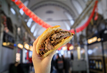A woman holds a donner kebab sandwich inside the Grand Bazaar, Istanbul, Turkey