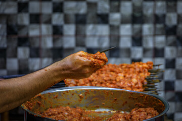A hand skewering raw meat pieces for traditional shish kebabs, Istanbul, Turkey