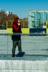 Redhead woman making a phone call in urban setting