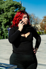 Redhead woman talking on phone outdoors in urban park
