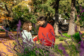Young couple holding hands and talking in a blooming park