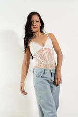 Young latin woman posing with white bodysuit and jeans on white background