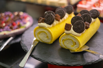Delicious yellow cake roll topped with chocolate cakes and whipped cream
