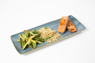 Grilled salmon fillet with quinoa and sautéed vegetables on a plate on a white background