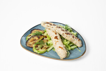 Grilled chicken kebabs with zucchini, eggplant, cucumber sticks, and fresh dill on a  plate. White background
