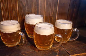 Prague, Czech Republic, August 5, 2023. Four mugs of beer in a brewery in the old town. The national drink, a symbol of the city. A symbol of conviviality and good times together.