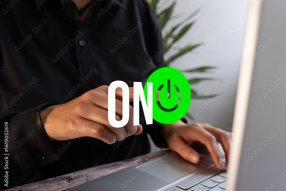 Poster person in front of their laptop while pointing in front of it with a floating icon of a power sign a