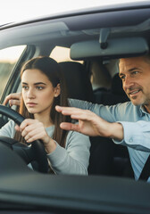 A father patiently teaches his teenage daughter to drive, a heartwarming and authentic moment of bonding, learning, and a key life milestone.