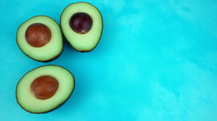 avocado halves with seeds, pastel backdrop with clean right margin
