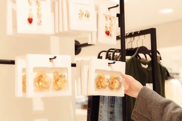 A girl looks at beautiful jewelry in a store.
