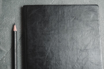 Notebook, pencil, headphones, glasses, camera, placed on a gray background.